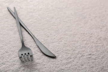 Stylish cutlery on beige textured table, closeup. Space for text