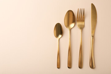 Stylish cutlery set on beige table, flat lay. Space for text