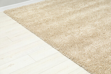 Soft beige carpet on white laminated floor indoors