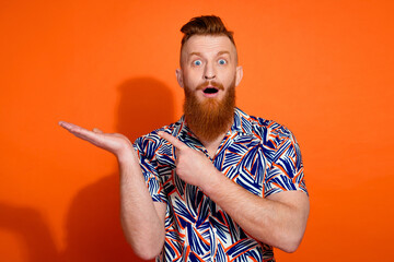Photo of impressed funky guy dressed print shirt showing arm pointing finger emtpy space isolated...