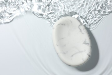 Presentation of product. Marble podium in water on white background, top view. Space for text