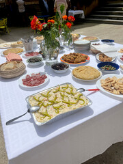 square table with food for a popular aperitif at a village festival. potato omelette, cheeses, sausages, croquettes on wooden boards, table with food for a popular aperitif at a village festival. 