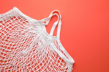White string bag on red background, top view. Space for text
