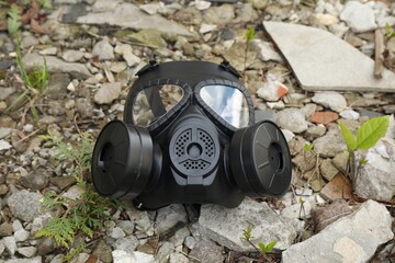 One gas mask on ground with stones outdoors