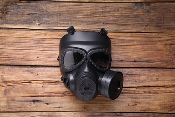 One gas mask on wooden background, top view