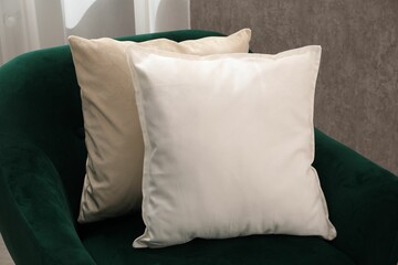 Soft pillows on green armchair in room