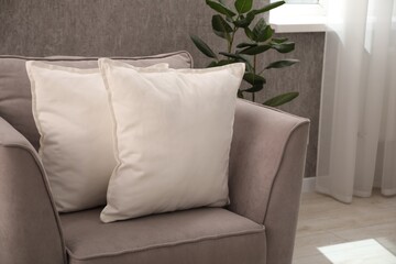 Soft pillows on armchair in living room