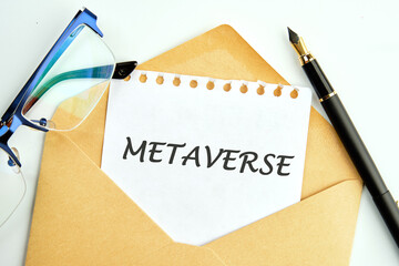 METAVERSE text an inscription on a piece of paper peeking out of an envelope next to glasses and a pencil
