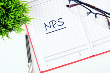 Business concept. NPS (Net Promoter Score) text written in an open business notebook on a blank sheet