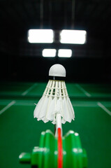 The shuttlecock is floating in a green badminton court net. background shot in low light