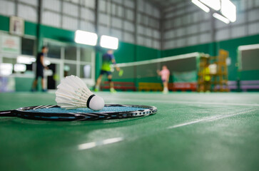Badminton rackets and white cream badminton shuttlecocks after playing or after games on green...