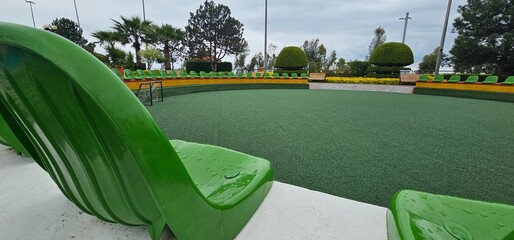 Green chair sits on artificial turf in the city