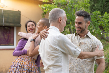 Multiethnic middle aged men and women greet each other and huddle together happily. High quality...