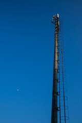 A towering transmitter station against a backdrop of an electric blue sky