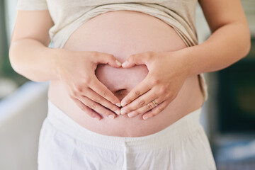 Hands, woman and pregnant stomach with heart for love or excitement for parenthood, motherhood and...