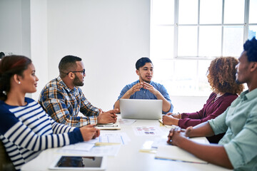Startup, laptop or people in meeting speaking of paperwork, feedback review or partnership together. Development, staff or designers talking for teamwork or planning in conversation for project brief