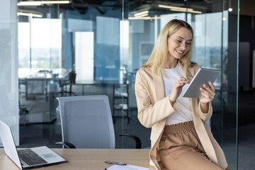 Female programmer using tablet in modern office setting