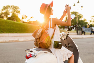 attractive woman riding on motorbike in street