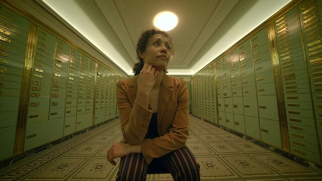 a woman is sitting in a hallway with lockers thinking about future investment