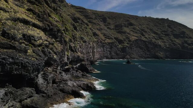 Fly across a rough tenerife coast line called Baja de los Cristianos at Caleton with splashing wavesTen