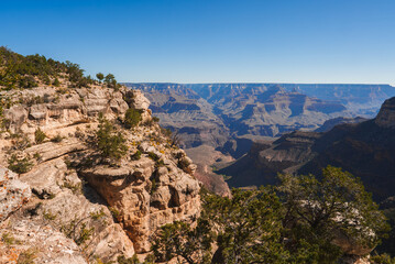 Scenic view of the Grand Canyon under a clear blue sky in Arizona, USA. Rugged, rocky terrain with...