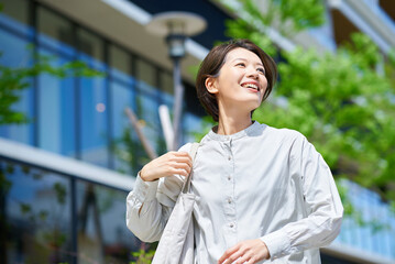 ショッピングバッグを持って街を歩く女性