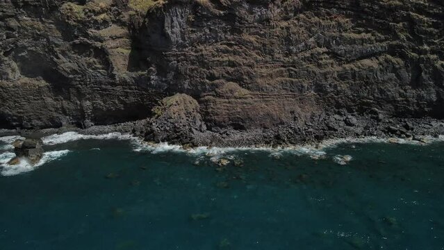 Fly across a rough tenerife coast line called Baja de los Cristianos at Caleton with splashing wavesTen