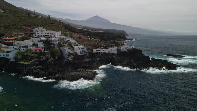 Fly across a rough tenerife coast line called Baja de los Cristianos at Caleton with splashing wavesTen