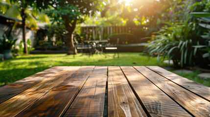 A wooden table top with an outdoor garden background, captured in a closeup shot with a blurred background. The scene is bathed in bright sunlight and features lush green grass, trees, and other plant