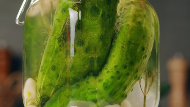 Close-up of fermented cucumbers with garlic in can. Preservation of vegetables in glass jars. Fermentation preserved cucumbers with spices. Russian cuisine.
