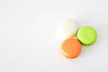 three different colored cookies are on a white surface 