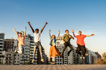 Happy millennials friends jumping outdoor