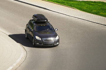 Car equipped with a rooftop cargo carrier amidst heavy traffic on a sunny day