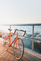 Fototapeta premium Orange Road Bicycle at the Seaside Sunset