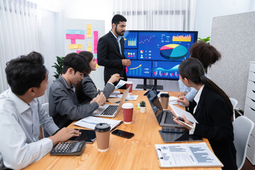 Businessman presenting data analysis dashboard display on TV screen in modern meeting for marketing...