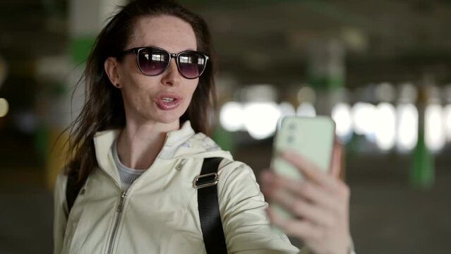 The average age of a woman wearing sunglasses in the parking lot of a shopping mall makes it possible to present the scene as realistic and attractive to a wide range of viewers.