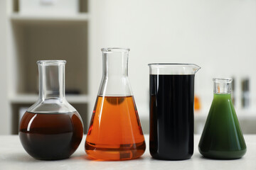 Flasks and beaker with different types of crude oil on light table