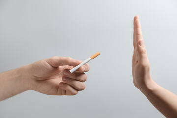 Man refusing cigarette on grey background, closeup