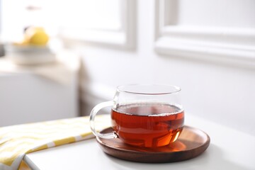 Tasty hot tea in cup on white table, closeup