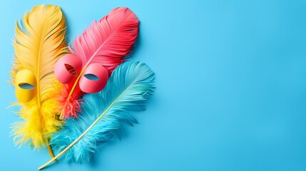   Three feathers, colored in hues of pink, yellow, and blue, against a backdrop of blue One feather dons a pink mask atop it, while another is plain