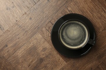 Hot coffee in cup on wooden table, top view. Space for text