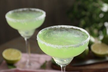 Delicious Margarita cocktail in glasses on table, closeup