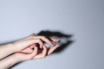 Shadow puppet. Woman making hand gesture like crocodile on grey background, closeup. Space for text