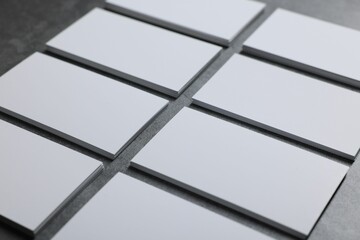 Obraz premium Blank business cards on grey textured table, closeup. Mockup for design