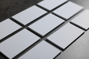 Obraz premium Blank business cards on grey textured table, closeup. Mockup for design