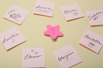 Choosing baby name. Paper stickers with different names and question mark on beige background