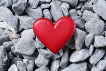 Obraz premium Red decorative heart on grey stones, top view