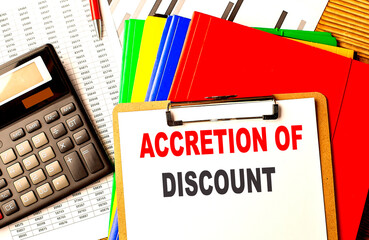 ACCRETION OF DISCOUNT text on clipboard with calculator and color folder