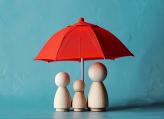 Wooden toys under red umbrella on blue background. Wooden toys family in life leave protection and care concept.