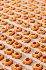 Modern line for bakery cookies with red jam, sunlight. Food industry, biscuit production in factory on conveyor belt